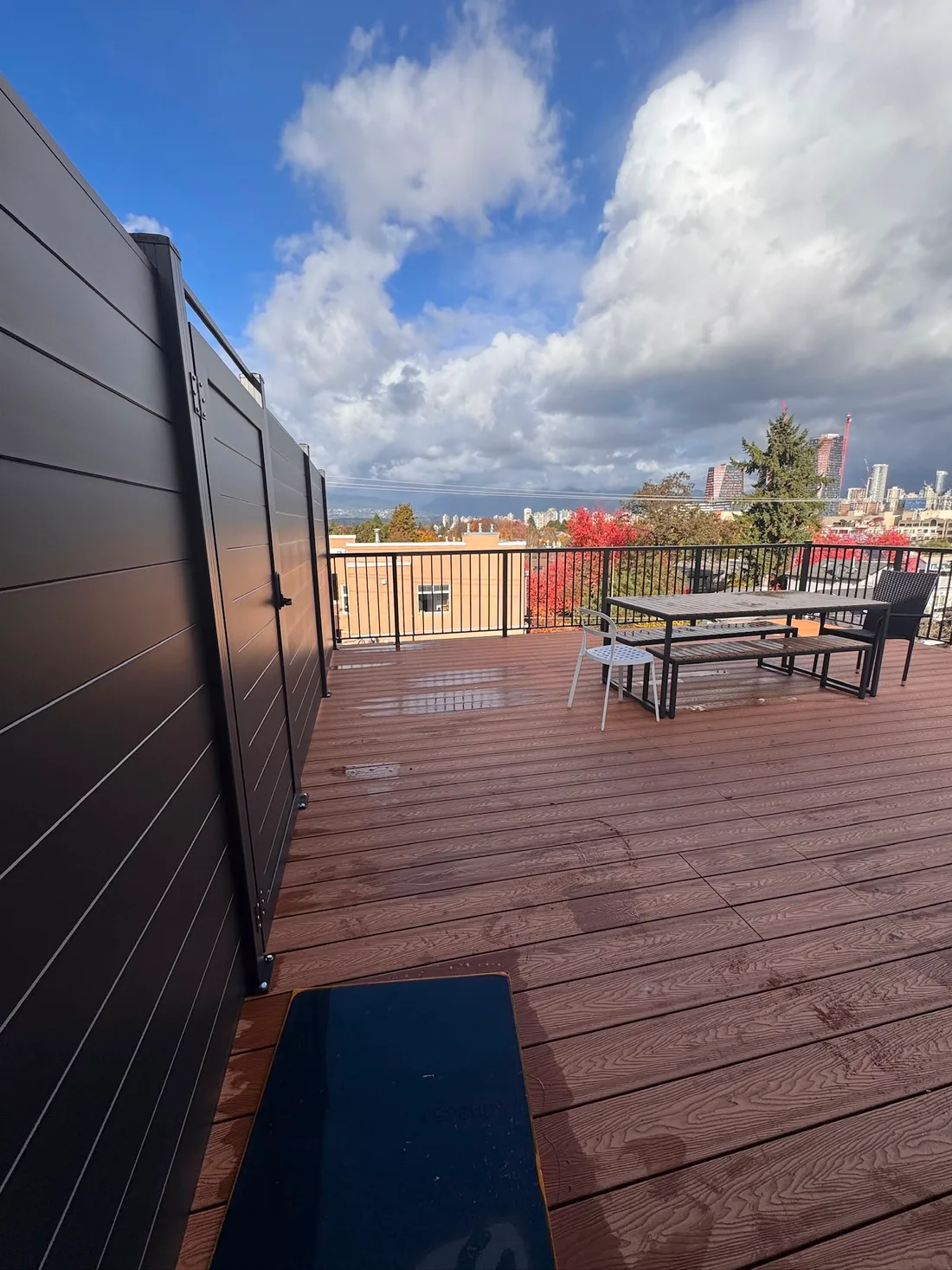 Composite rooftop deck with privacy screen and outdoor seating in Vancouver